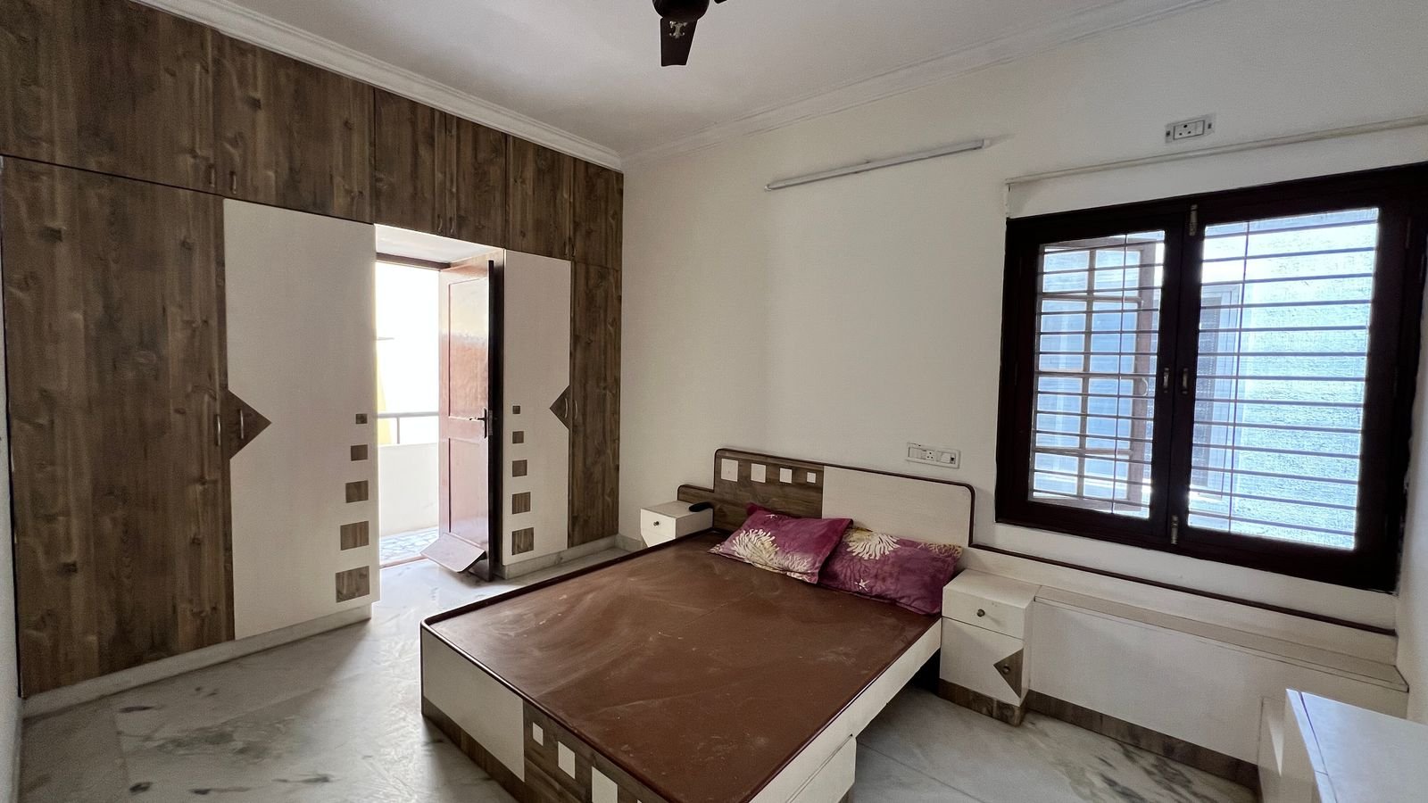 2BHK apartment master bedroom with double bed, wardrobe and window in HSR Layout, Bangalore – Renthouzz