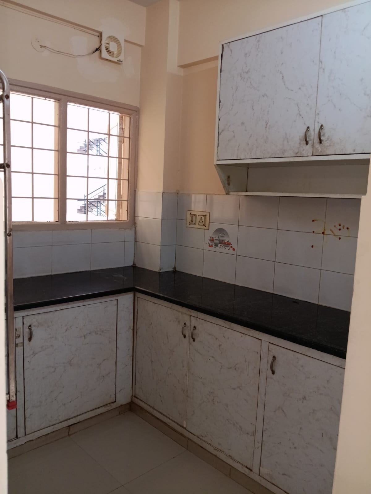 Modular kitchen with storage cabinets and utility area in Electronic City apartment