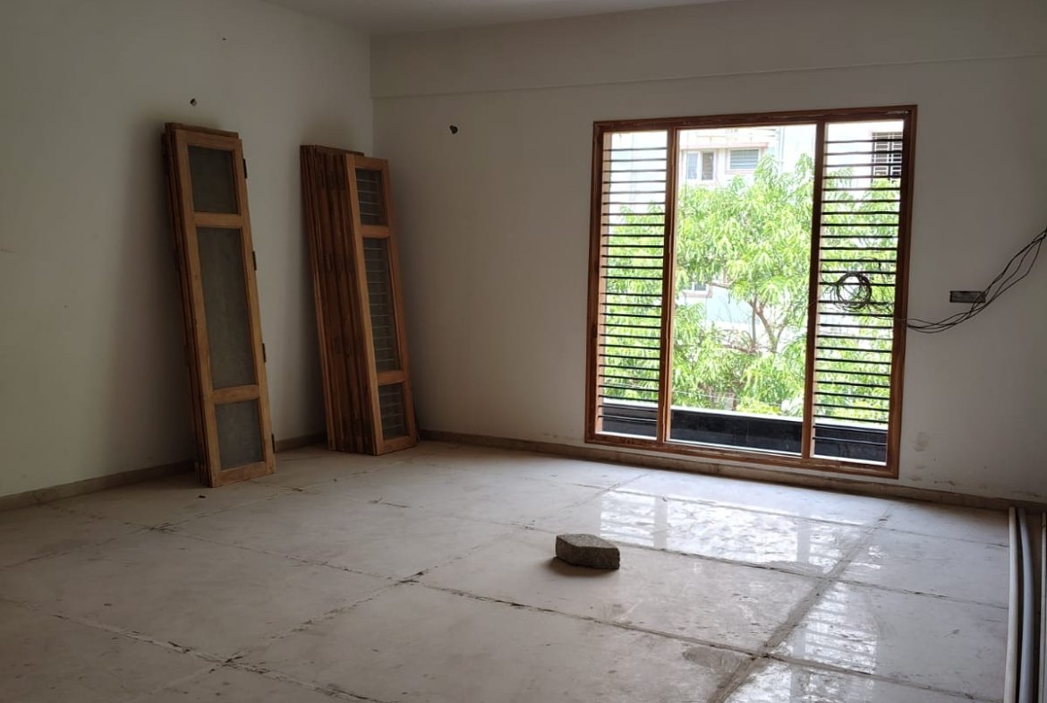 Spacious living room interior of 3BHK flat with balcony and natural light