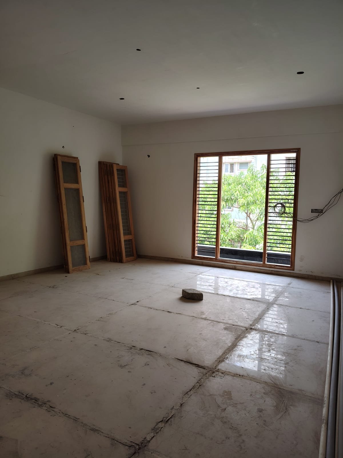 Spacious living room interior of 3BHK flat with balcony and natural light