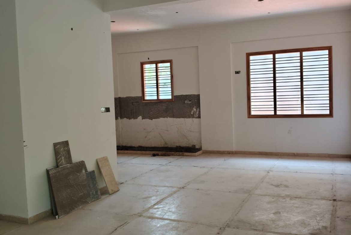 Spacious living room interior of 3BHK flat with balcony and natural light