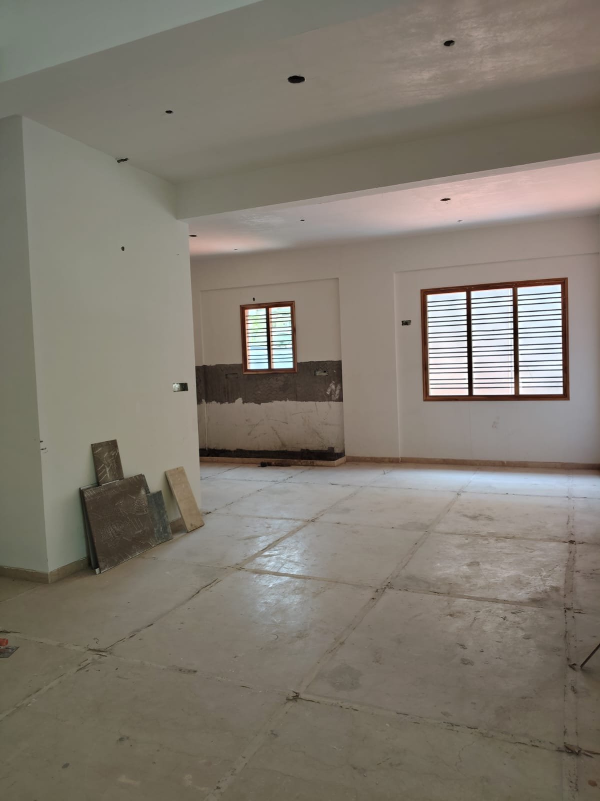 Spacious living room interior of 3BHK flat with balcony and natural light