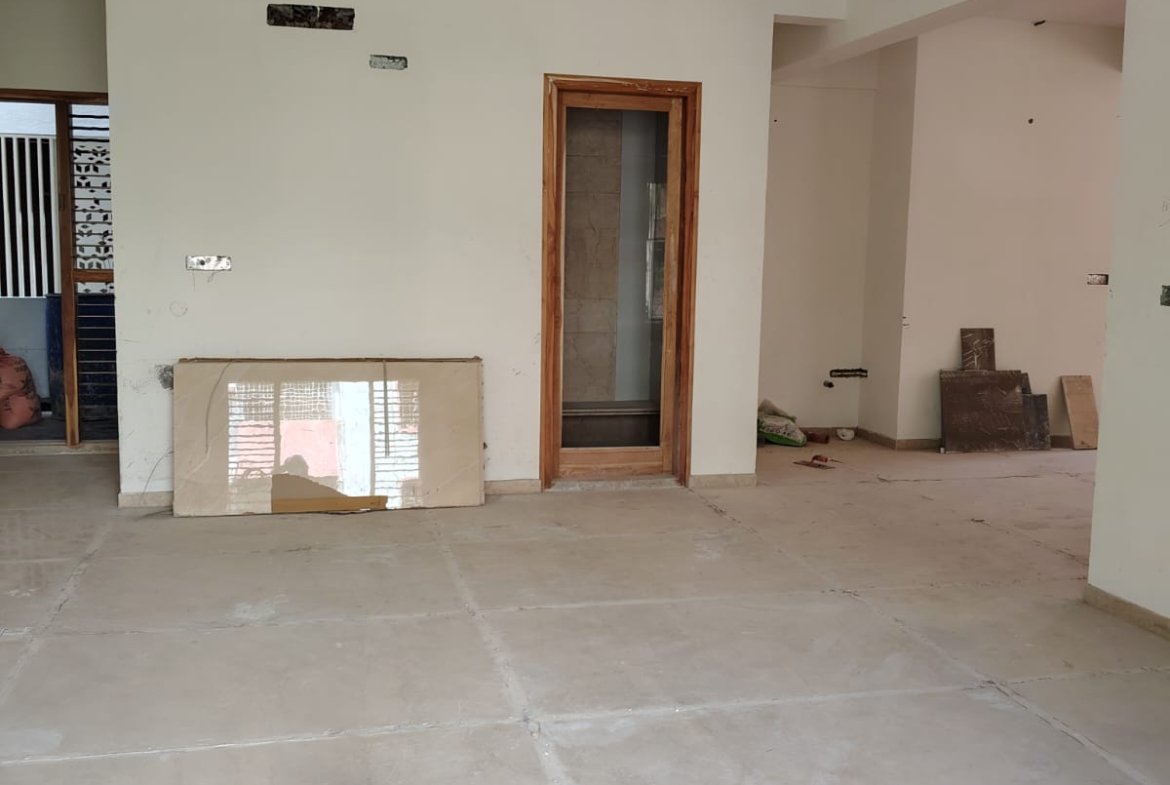 Spacious living room interior of 3BHK flat with balcony and natural light