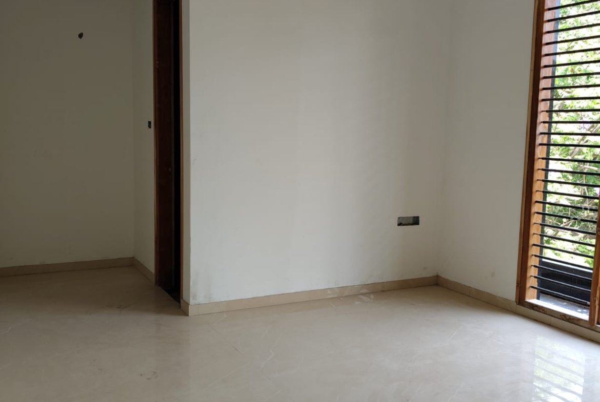 Spacious living room interior of 3BHK flat with balcony and natural light