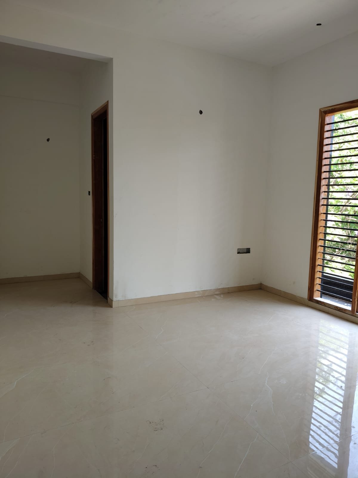 Spacious living room interior of 3BHK flat with balcony and natural light