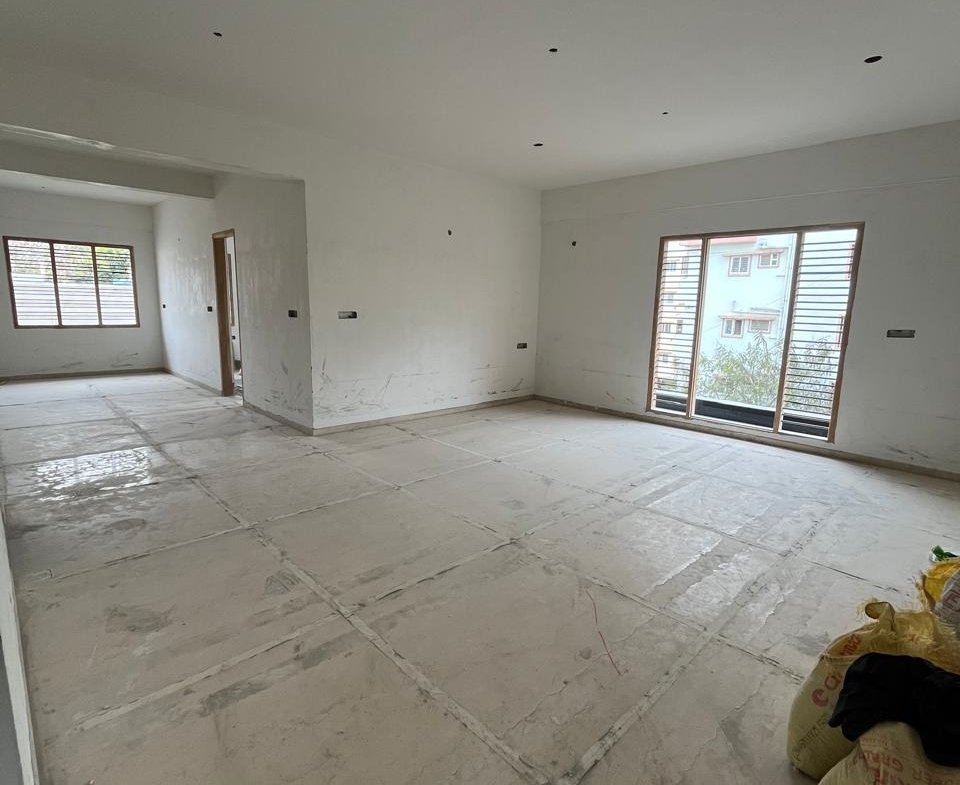 Spacious living room interior of 3BHK flat with balcony and natural light