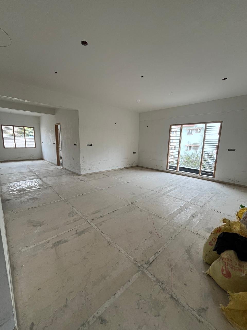 Spacious living room interior of 3BHK flat with balcony and natural light