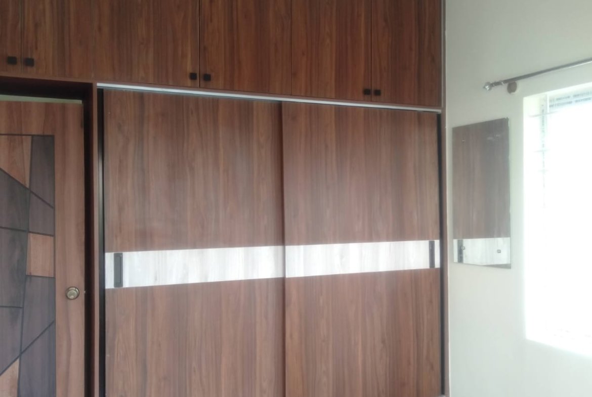 Cozy bedroom in 1200sqft 2BHK flat with balcony cupboards and balcony view Bannerghatta Road Bangalore.