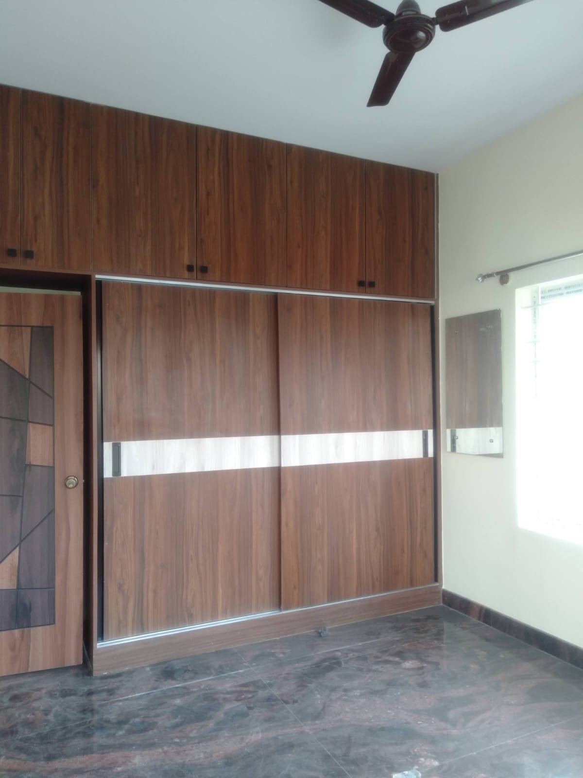 Cozy bedroom in 1200sqft 2BHK flat with balcony cupboards and balcony view Bannerghatta Road Bangalore.